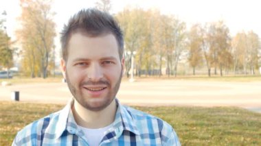 Parkta duruyor ve kameraya yakın çekim, uyuşuk, kopya alanı bir genç Genç ve yakışıklı bir adam portresi,