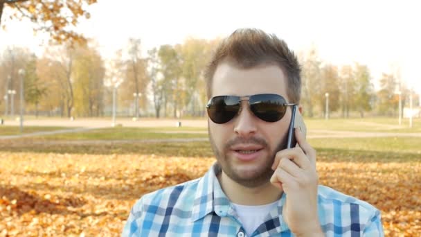 Bonito homem caucasiano na moda falando ao telefone e fumando vape, close-up, slow-mo, cigarro eletrônico — Vídeo de Stock