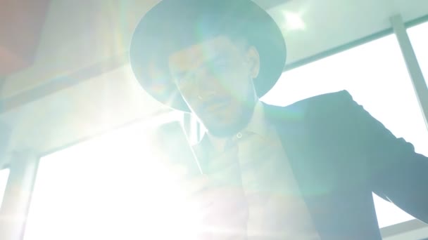 Eleganta vita mannen i svart kostym och hatt håller telefonen i sin hand och läsa information samtidigt som det är på flygplatsen, närbild, slo-mo — Stockvideo