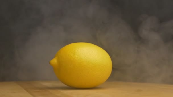 Rotierende reife Zitrone, die Kühle und Frische atmet, Verdunstung, auf schwarzem Hintergrund, Zeitlupe — Stockvideo