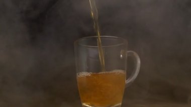 Taze elma suyu bir fincan içine dökülür hangi duman döner, siyah arka plan, ağır çekim, elma suyu, taze