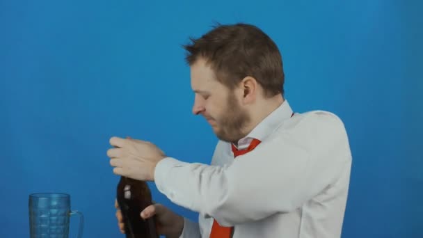 Unshaven careless man like a alcoholic pours beer into a mug and drinks ale or lagger — Stock Video