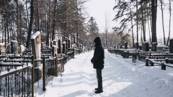 Člověk truchlí nebo truchlí pro mrtvého muže v hřbitově nebo hřbitov v zimě v lese — Stock video