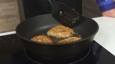 Bir adam bir tava, yağ, abur cubur, yakın çekim, ağır çekim bir sürü yağlı pirzola patates kızartması, 