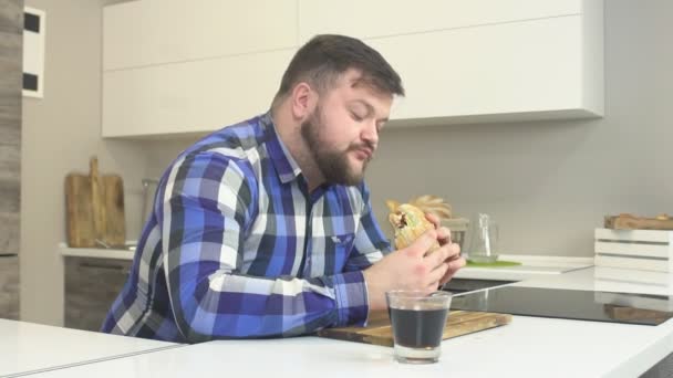 Dikke bebaarde man eet junkfood cheeseburger met pijn fastfood, calorieën, slow motion, limonade — Stockvideo
