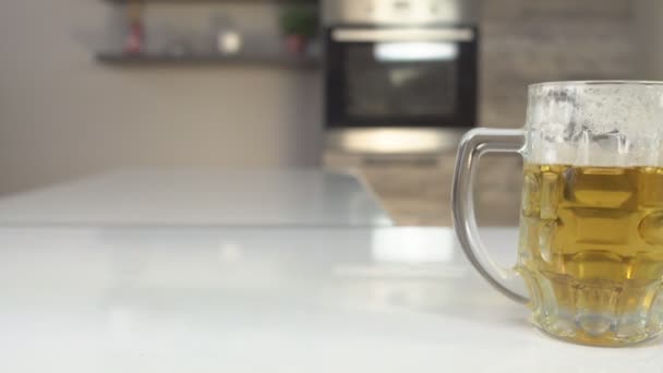 Beer glass with beer and a plate with chips is on the table in the kitchen, eating food, background — Stock Video