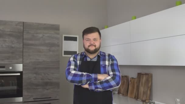 Şişman beyaz sakallı erkek önlük aşçı mutfakta ayakta ve kameraya 4 k arıyorsunuz — Stok video