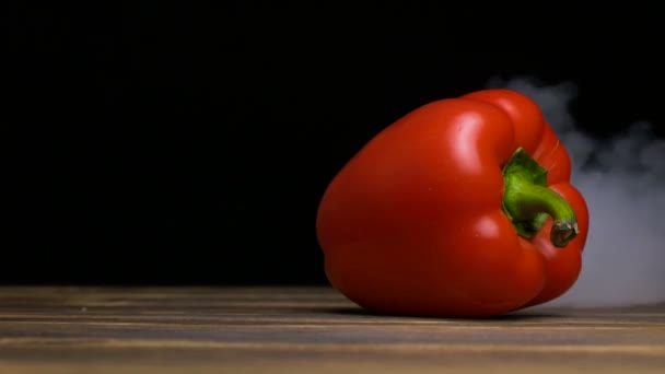 Ώριμα φρέσκο πιπέρι κουδουνιών ή capsicum είναι στο τραπέζι και καπνός χτυπήματα από πίσω, cloese έως 4 k, αντίγραφο χώρου — Αρχείο Βίντεο