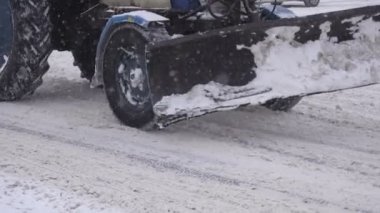 Kar temizleme için eski bir traktör sürmek bir kış city, kar yağışı, ağır çekim