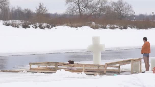 BOBRUISK, BELARUS - 19 JANVIER 2019 : Baptême des fêtes hommes et filles se baignent dans un trou de glace en hiver, au ralenti — Video