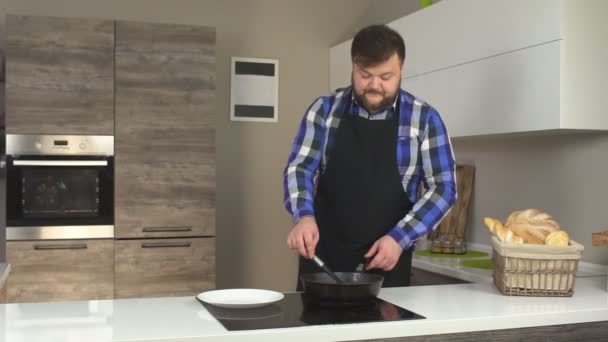 Hombre Barbudo Fríe Chuletas Cocina Una Sartén Chuletas Vylazhivaet Plato — Vídeo de stock