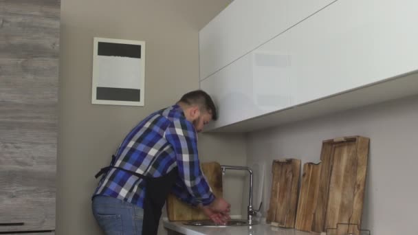 Bello uomo con la barba si lava le mani prima di cucinare in cucina moderna, rallentatore, igiene — Video Stock