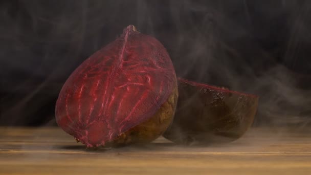 Natuurlijke sappige bieten op een zwarte achtergrond in de rook, die is van zweet en versheid, close-up, Slowmotion, rode biet — Stockvideo