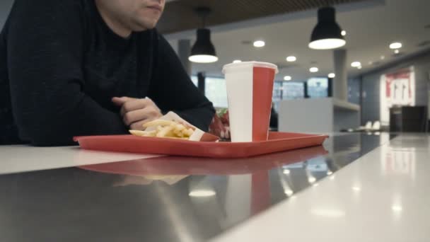 Hombre va a comer una comida rápida, hamburguesa, papas fritas, bebida carbonatada — Vídeo de stock