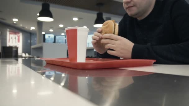 Mann Zunge leckt sich den Mund, bevor er einen Hamburger oder Chiken Burger in slowmo isst — Stockvideo