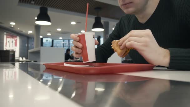 Timelapse man äter hamburgare, drycker söta kolsyrat vatten i snabbmatsrestaurang — Stockvideo