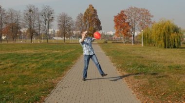 Moda ve şık adam bir park, uyuşuk, yaşam tarzı karşı kırmızı balon dansları ile siyah gözlük