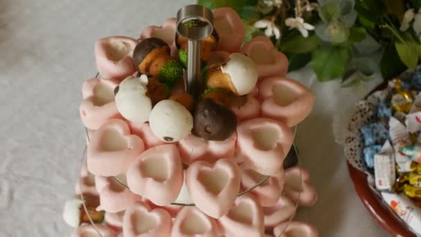 Doces festivos na forma de um coração, uma mesa com doces, close-up, decorado, biscoito — Vídeo de Stock