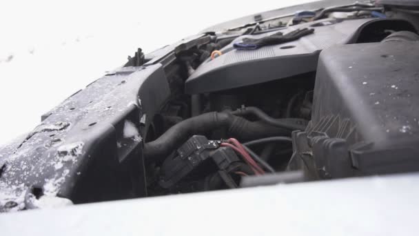 Engine compartment of the car in the winter, it is snowing, car breakdown in the winter, diesel fuel freezing, slow motion — Stock Video