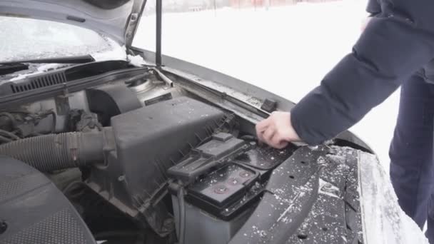 Мужчина Устанавливает Автомобильный Аккумулятор Затягивает Терминал Зиму Снег Разряд Батареи — стоковое видео