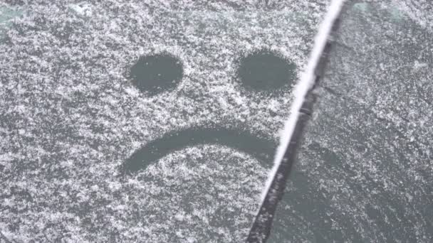 Trauriger Smiley auf Autoscheibe von Schnee, der vom Scheibenwischer entfernt wird, Kopierraum, das Ende des Winters, Zeitlupe — Stockvideo