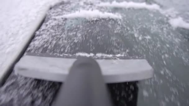 Limpieza de vidrio de coche de hielo y nieve con un rascador, primer plano, cámara lenta, al aire libre — Vídeos de Stock