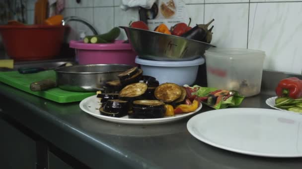 Cortar en rodajas de berenjena verduras comida está en un plato en una cocina en un restaurante o cafetería, catering — Vídeos de Stock