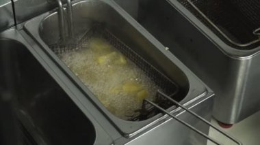 Ayçiçeği yağı Restoran Derin fritöz yavaş hareket, patates kızartması kafeler mutfakta yemek fast food patates parçaları yanmış, bitkisel yağ yağlı ve yüksek kalorili lokanta kızartma için yeniden