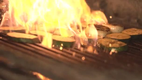 Vegetables are roasted on fire and coal on barbecue grill in slow motion in oven in restaurant or cafes kitchen — Stock Video