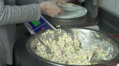Cook et salata sebze ile bir kısmını ölçeklerde Restoran mutfakta bir tabak içinde koyar