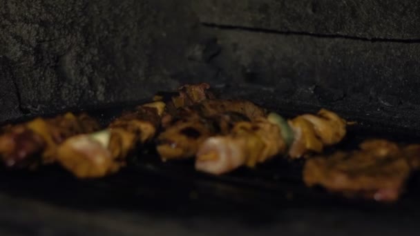 Worst en stukken vlees worden gekookt, gebakken op de barbecue grill in de oven over kolen in restaurant of cafetaria's keuken — Stockvideo