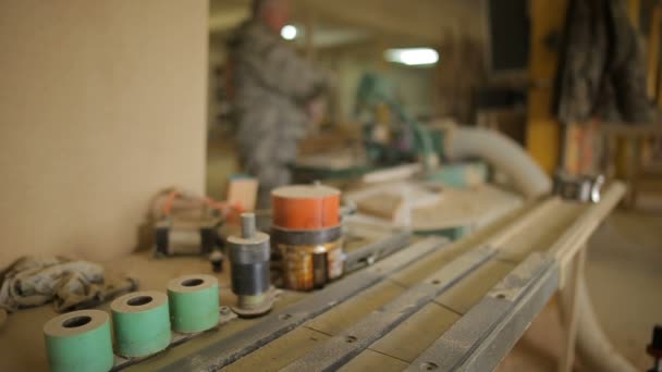 Se centran en la máquina de carpintería, carpintero trabaja en taller sobre fondo — Vídeos de Stock
