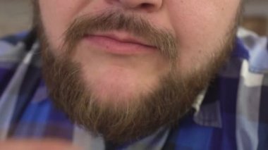 Kilolu adam ve sakal yeme Yağlı cips, abur cubur, kolesterol, yakın çekim, ağır çekim, arka plan