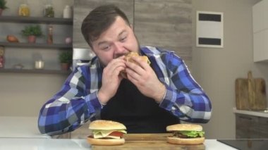 Sakallı şişman adam besleniyormuş mutfak lokanta hamburger, ekstra kalori, ağır çekim, oburluk