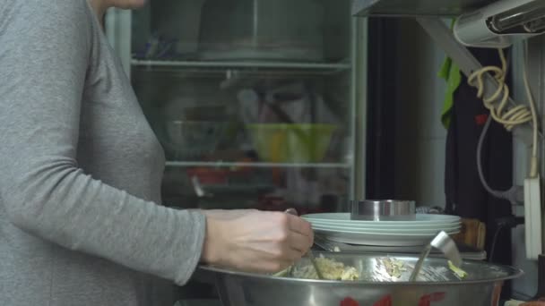 Een kok in de keuken gedeelten van salade op schalen in gram weegt en dient om de tabel — Stockvideo