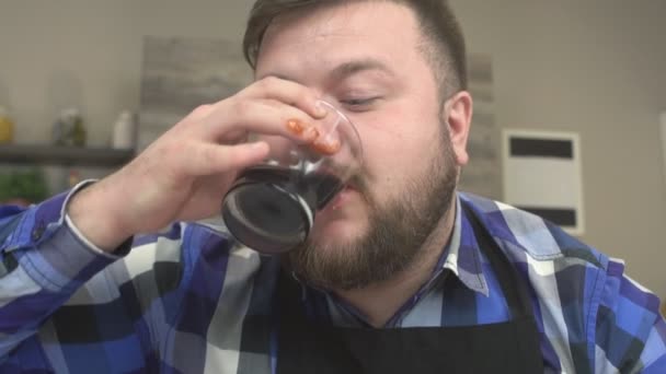 Fet man med ett skägg dricka skadliga soda och njuter av mat, närbild, Slowmotion — Stockvideo