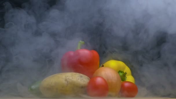 Composition or set of vegetables spin and smoke or steam blows from behind in slowmo, copy space — Stock Video