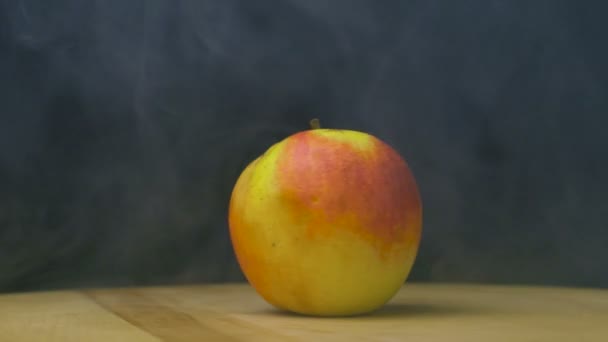 Ripe farm Apple spins in smoke or steam in slow motion, close up, copy space — Stock Video