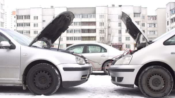 İki araba bağış motoru başlatmak için kablo kullanarak kışın atlama başlatmak, aküsü bitti — Stok video