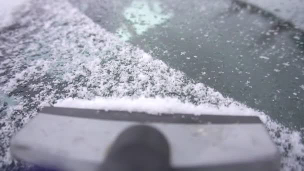 Cleaning car glass from ice and snow with a scraper, close-up, slow motion, outdoor — Stock Video