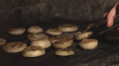 aşçı patates soğan barbekü ızgara veya iç fırın slowmo kafede kömürlerin üzerinde kesme, dilimlenmiş soğan yakından restoranlar mutfak ağır çekimde kömür üzerinde duvar fırında ızgara
