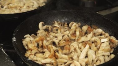 Tavuk eti ve mantar petrol adet kızartılmış veya bir tava veya restoran mutfak gaz sobası ağır çekimde üzerinde tavada pişirilir