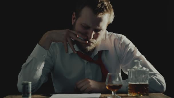 Moe zakenman rookt en documenten bekijkt, alcoholische drank of drankje ligt op tafel, een belangrijke transactie sluiten — Stockvideo