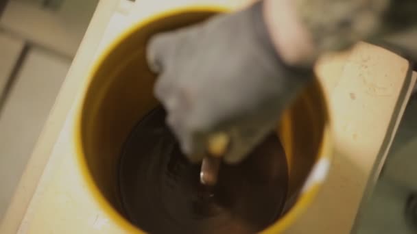 homme plonge son pinceau dans le vernis à bois et vernis un produit en bois ou une partie de meubles 