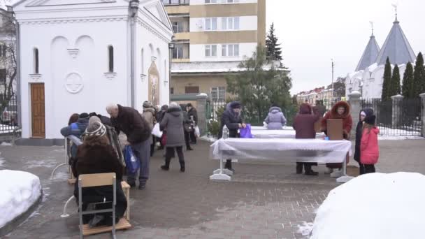 БОБРУЙСК, БЕЛАРУС - 19 ЯНВАРЯ 2019 года: Празднование крещения в церкви, люди собирают святую воду в храме, традиции, замедленная съемка — стоковое видео