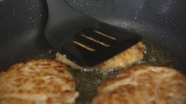 Bir tavada zeytinyağı, yağlı abur cubur, yakın çekim, ağır çekim bir sürü yağlı sulu pirzola yanmış