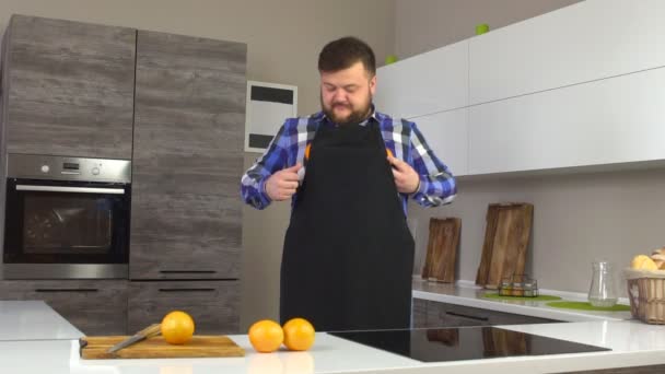 Un uomo con la barba scherzare con le arance in una cucina moderna, una dieta sana, lento mo — Video Stock