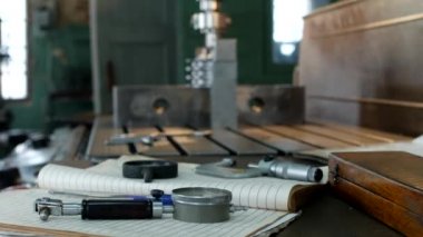 Kasnak, ölçme araçları, üretim, küçük işletme tablo yalan üzerinde bir delik delme makinesi arka planda metal parçalar ile çalışmak için özel bir atölye matkaplar