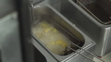 Bir fritöz patates olan kırsal tarzda, fast food, ağır çekim, abur cubur yağda kaynar