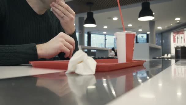 Pria setelah makan menyeka wajahnya dengan serbet dan tidak membuang sampah di restoran cepat saji — Stok Video